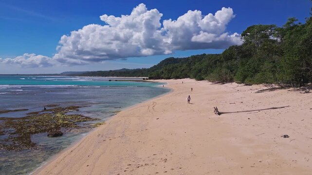 Aerial view of lonely surfer at tropical island coastline, Plengkung Beach,Alas Purwo National Park, East Java, Indonesia