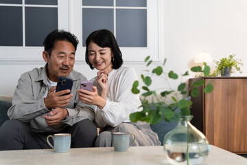 スマートフォンで調べものをするミドル夫婦　ライフスタイルイメージ