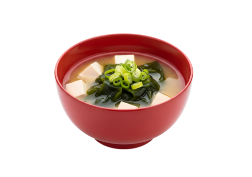 Close-up of a vibrant red bowl brimming with a comforting miso soup, featuring tofu, seaweed, and green onions.