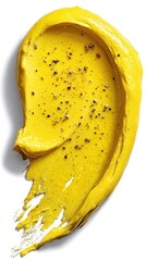 Swirl of bright yellow sauce speckled with black pepper