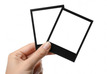 Hand holding two blank instant photo frames isolated on transparent background