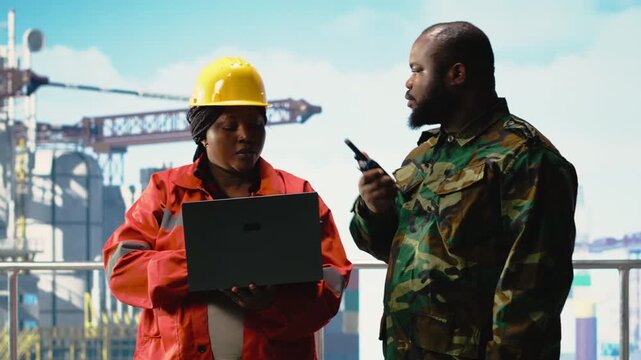 Soldier working on offshore platform transmitting security report with walkie talkie. Military unit boarding drilling barge under maritime interdiction protocol coordinates defense operation, camera B