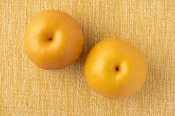 黄色い布の上に置かれた2個の梨（豊水）