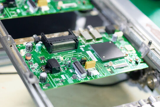 Conveyor transporting electronic boards in a manufacturing facility during an automated assembly process
