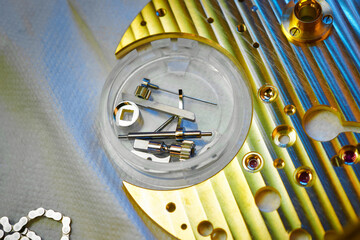 Intricate clock mechanism spare parts laid out for precision assembly in a workshop setting