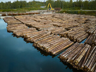 Water log storage facility with stacked logs ready for processing in a serene natural setting