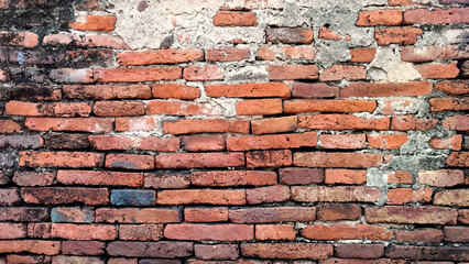 old cracked concrete wall with exposed red brick texture. vintage grunge wall background showing...