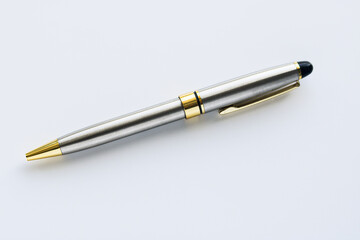 A sleek, modern ballpoint pen, featuring a brushed silver barrel with polished gold accents, positioned at an angle on a clean white background. Used for writing, signing, or as a an office accessory.