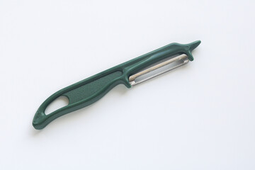 A compact vegetable peeler with a sharp stainless steel blade and ergonomic green handle. A go-to tool for home cooks and chefs when preparing fresh produce.