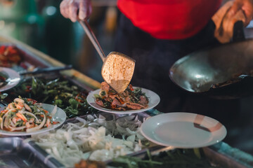 Stir-fried food, being served on a plate, being served on a plate
