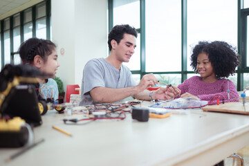 A teacher guiding students in a robotics project during a STEM class in the library
