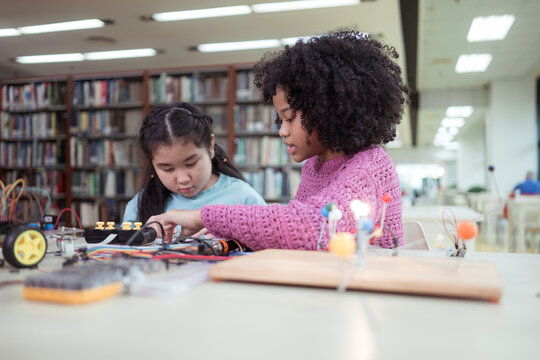 A kid students in a robotics project during a STEM class in the library
