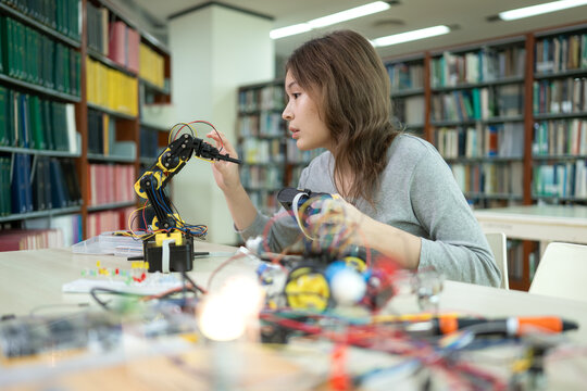 A teenage girl student in a robotics project during a STEM class in the library