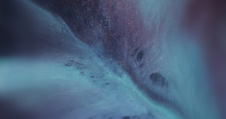 Blur ripple texture. Ink blend. Defocused blue purple color sparkling water glitter liquid floating on abstract dark black background.