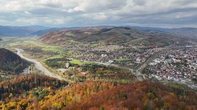 Drone footage over Gura Humorului showing the city, Arinis Park, and autumn forest colors in Bucovina, Romania