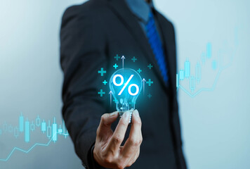 Businessman holding light bulb with digital percentage icon and stock graph. Concept for financial idea, innovation, investment growth, interest rate, and business success.