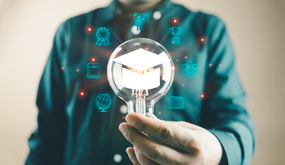 Man holding a lightbulb showing a graduation hat, an Internet education course degree, knowledge creative thinking idea problem-solving solution, E-learning graduate certificate program concept
