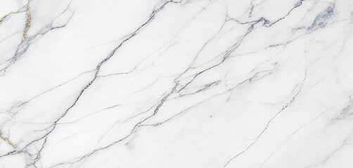 Fototapeta premium White marble surface photographed top-down, showing intricate gray and gold veining details with a smooth reflective texture, softly lit to reveal its refined natural luxury and tonal balance.