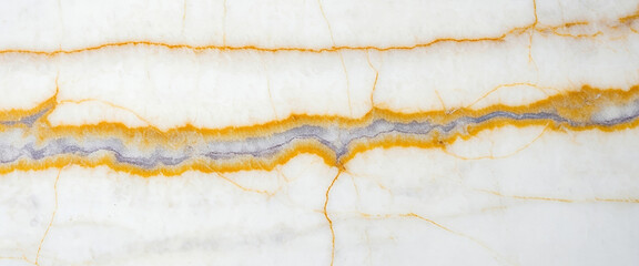 Close-up of a white and gold onyx stone surface with soft gray banding through the center, glowing under diffused light to highlight its translucent depth and luxurious pattern.