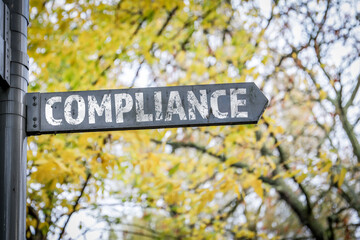 Compliance. Metal sign, arrow pointing direction symbolizing regulation, policy and ethical business standards
