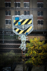  Metal crane hook featuring black and yellow warning stripes, symbolizing heavy industry, construction and workplace safety
