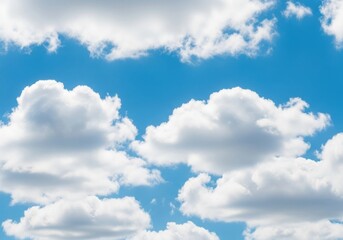 Fototapeta premium Fluffy white cumulus clouds floating in a clear blue sky on a sunny day