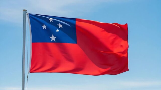 The national flag of Samoa waving proudly in the wind against a clear blue sky, symbolizing national identity and pride.