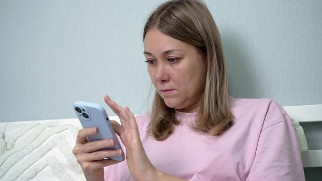 In her cozy room, a woman feeling unwell uses a mobile app to order necessary medications. She focuses intently, seeking relief and a solution to her sickness.