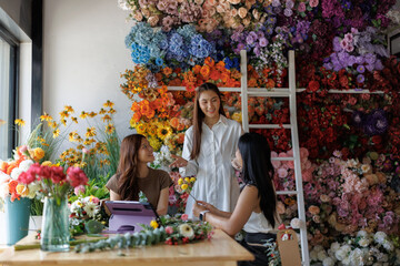 Florist women collaborating creating flower arrangement
