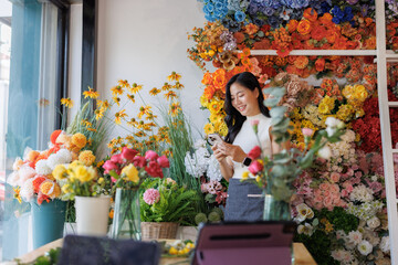 Young woman managing online flower business with phone