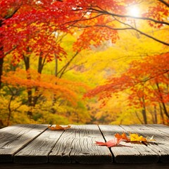 Autumn leaves on a wooden table with a colorful forest background