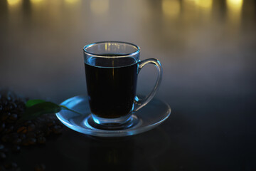 Hot Black Coffee Glass Cup On Transparent Saucer With Coffee Beans And Leaf