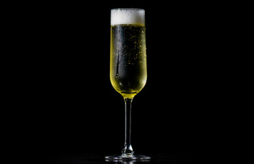 Festive pour of champagne with bubbles. Champagne glass shining with effervescent bubbles. Sparkling wine with bubbly champagne in wine glass.