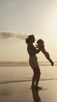 Mother and Child Dancing with Ocean Sunset Light, Symbol of Hope, Freedom and Love, Emotional Parenting Scene, Family Travel Inspiration, Connection and Joy, Modern Life Harmony Concept