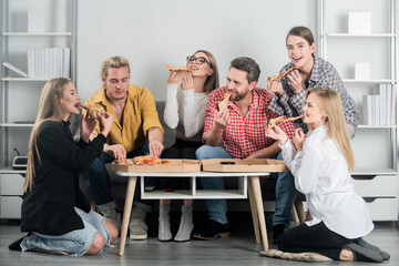 Group of friends eating pizza. Pizza with friends. Friends enjoying delicious pizza in a living room. Weekend with good company and tasty pizza.