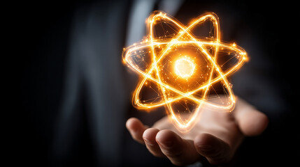 Human hand holding a glowing atom model, symbolizing knowledge, science, discovery, innovation, and the power of human understanding in physics, chemistry, and technological advancement