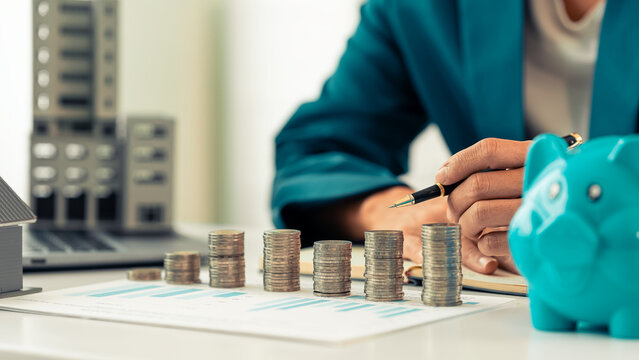 Business concept of accounting, investing and finance. Stack coins into a piggy bank to save money. Plan and save for the future and retirement fund.