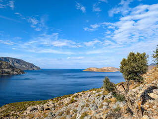 Panoramic view of Arginonta Bay on the island of Kalymnos in Greece. It is a popular destination for sport climbers. A small pine tree in the foreground