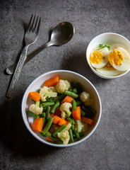 Healthy breakfast food items boiled vegetables and eggs. Top view