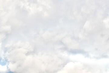 A detailed, closeup view of dense, towering cumulonimbus clouds, showing various shades of white and grey, suggesting heavy weather and dramatic atmospheric depth.