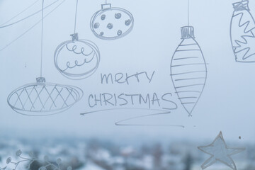 Sustainable responsible holiday decor. Merry Christmas text painted on window glass indoor at home. Christmas winter decoration. White pattern. Snow art tracery on season. Diy. Hygge home
