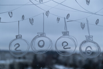 2026 Painted window with white marker. New Year number decoration on big clear window. Snowy winter outside. Zero waste decor conscientious celebration. Holiday preparation