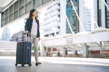 Adult business asian woman walking with luggage for work and travel at station platform on day © dodotone