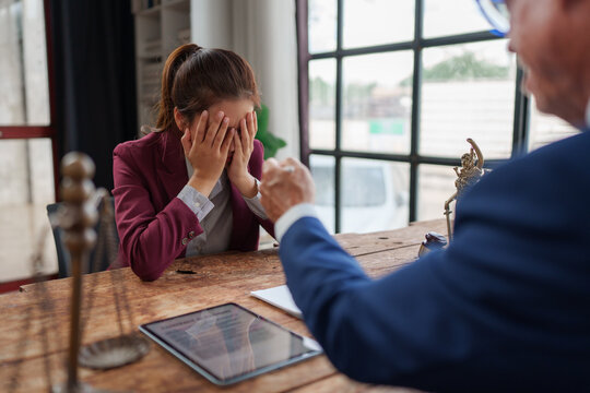 Woman experiencing distress during legal discussion with lawyer - Powered by Adobe