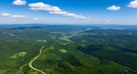 Obraz premium Dahong Mountain Under Blue Sky with Clouds and Vast Green Valleys Featuring a Winding Path Leading to the Horizon 