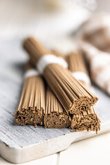 Buckwheat soba noodles on white table.