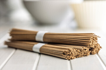 Buckwheat soba noodles on white table.