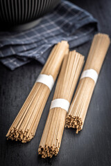 Buckwheat soba noodles on black table.