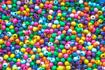 Colorful beads. Colorful wooden beads background. Wallpaper. Wristband equipment. Hobby, leisure activity. Top view, above, up. 