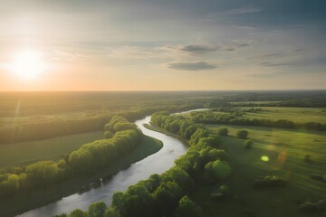 Serpentine river winding through lush green countryside under a golden sunset sky with soft clouds casting gentle shadows across the landscape
